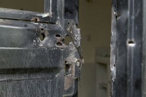 In this photo taken Wednesday, Aug. 3, 2016 and released by Adriane Ohanesian, bullet holes are seen in a metal door that was shot open at the Terrain compound after it was looted the previous month in the capital Juba, South Sudan. On July 11, South Sudanese troops, fresh from winning a battle in Juba over opposition forces, went on a nearly four-hour rampage through a residential compound popular with foreigners, in one of the worst targeted attacks on aid workers in South Sudan's three-year civil war. (Adriane Ohanesian via AP)