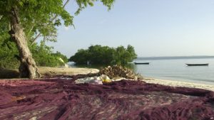 FILE - A fisherman's net is stretched out to dry on a beach on Pemba island, a tropical getaway that's part of the Zanzibar archipelago 80 kilometers off the coast of Tanzania in the Indian Ocean.