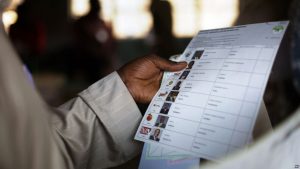 FILE - Kenyan voter holds a presidential ballot at a polling station in the Kibera slum in a general election in Nairobi, Kenya.
