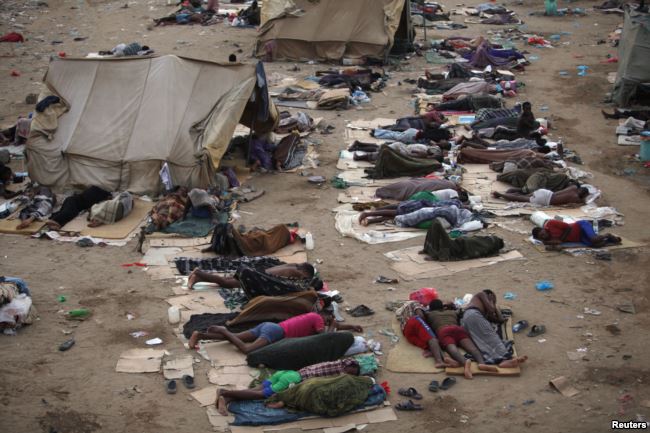 FILE - Ethiopian migrants sleep out in the open near a transit center where they wait to be repatriated, in the western Yemeni town of Haradh, on the border with Saudi Arabia, May 21, 2013.