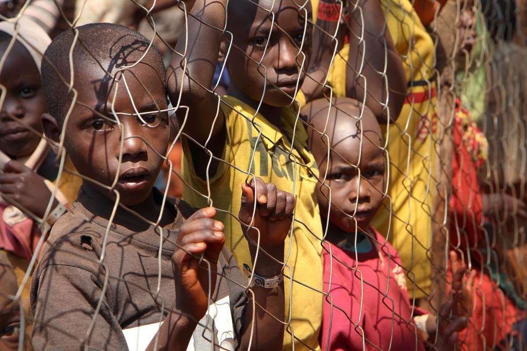 Burundian children, who fled their country, stand behind a fence as they wait to be registered as refugees at Nyarugusu camp, in north west of Tanzania, on June 11, 2015. (Stephanie Aglietti/AFP/Getty Images) 