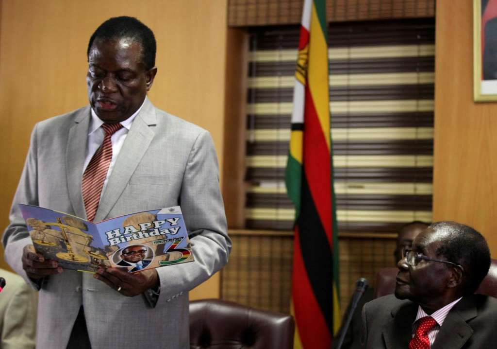 FILE PHOTO: Zimbabwe's President Robert Mugabe looks on as his deputy Emmerson Mnangagwa reads a card during Mugabe's 93rd birthday celebrations in Harare, Zimbabwe, February 21, 2017. REUTERS/Philimon Bulawayo/File Photo
