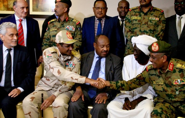 African Union envoy to Sudan Mohammed el-Hassan Labat (L) sits next to Sudan's deputy chief of the ruling military council General Mohamed Hamdan Dagalo as he shakes hands with an army general following a press conference in Khartoum (AFP Photo)